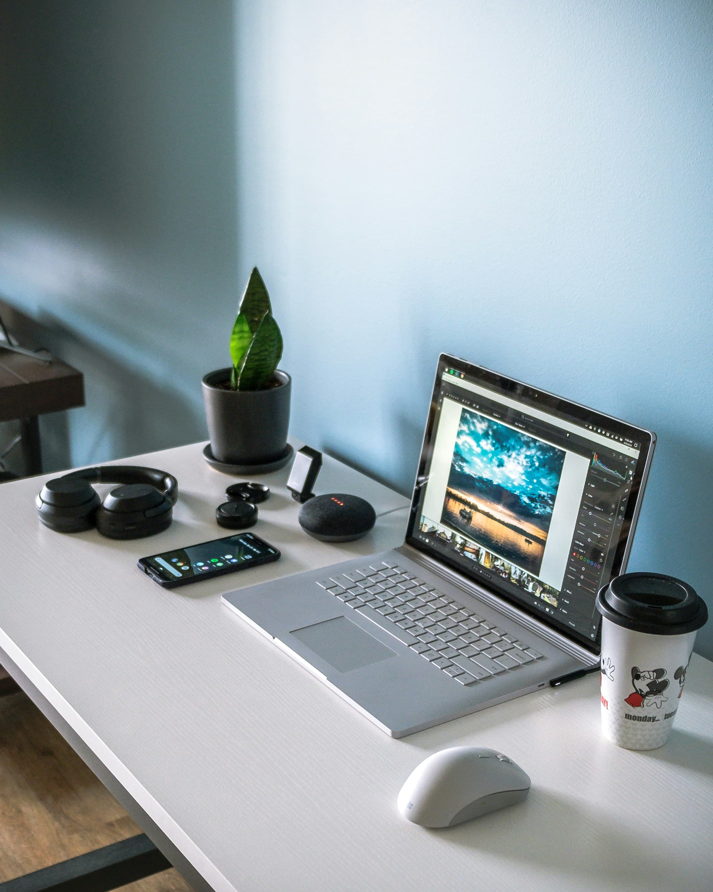 Laptop displaying productivity apps on a clean desk next to a notebook and coffee